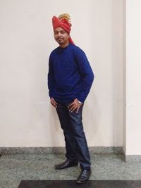 Portrait of young man standing against wall