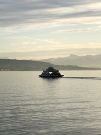 Boat sailing in sea against sky during sunset