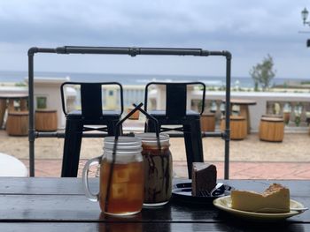 Close-up of glasses on table against sky