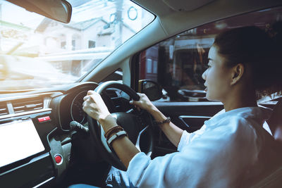 Midsection of woman sitting in car