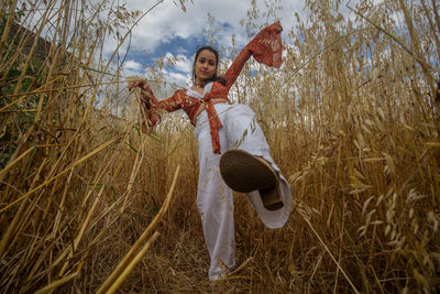 Man holding umbrella standing on field