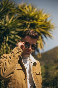 Fashionable young man wearing sunglasses and jacket during sunny day