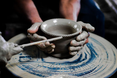 Cropped hands making clay pots