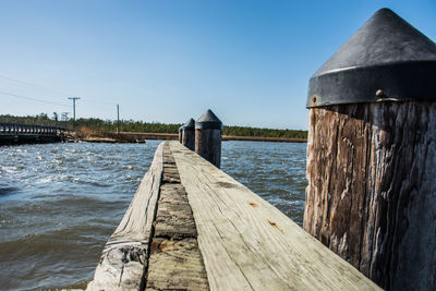 Wooden pier over sea against clear sky