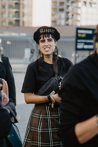 Portrait of young woman standing in city