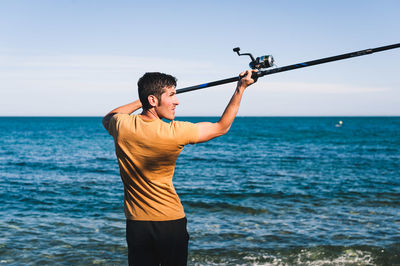 Man standing in sea against sky