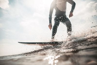 Man surfing on sea against sky