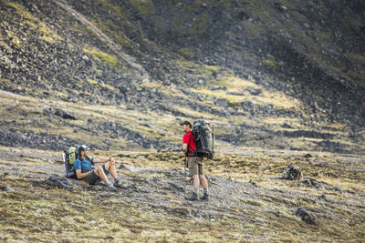 Backpackers rest in alpine meadow during a muti-day trip.