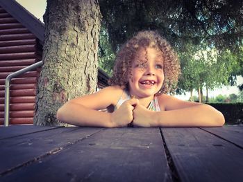 Cute girl looking away while sitting at table outdoors