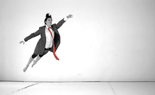 Full length of man jumping against white background