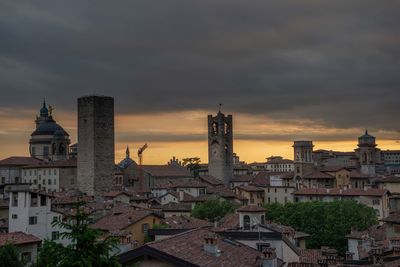 Buildings in city against sky during sunset