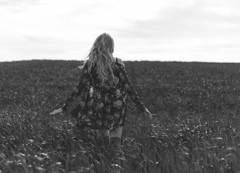 Rear view of woman on field against sky