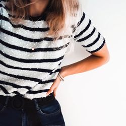 Midsection of woman standing against white background