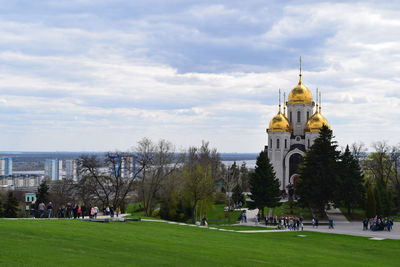 Trees and buildings in city against sky