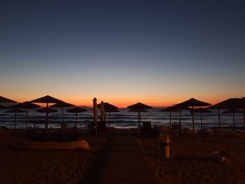 Scenic view of beach against clear sky during sunset