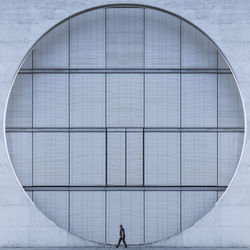 Reflection of man on glass building