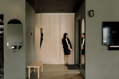 Female real estate agent standing by wall at new house