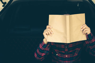 Midsection of person holding book