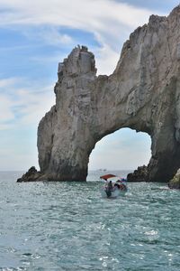 Scenic view of rock formation in sea against sky