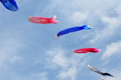 Low angle view of koinobori against sky