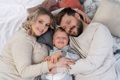 Portrait of smiling father and daughter on bed