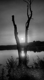 Silhouette of man in lake against sky