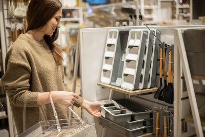Woman buying cutlery tray in store