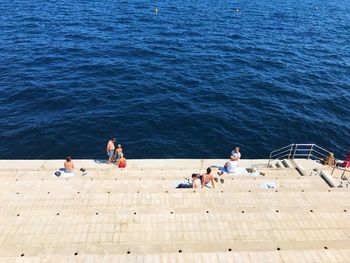 High angle view of people on sea shore against clear sky