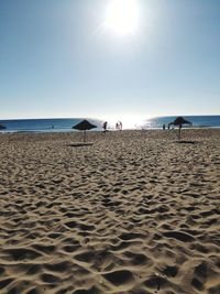 Scenic view of beach against sky on sunny day