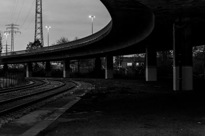 Railroad tracks by bridge against sky