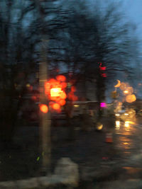 Defocused image of illuminated city street during rainy season