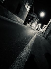 Surface level of road amidst buildings at night