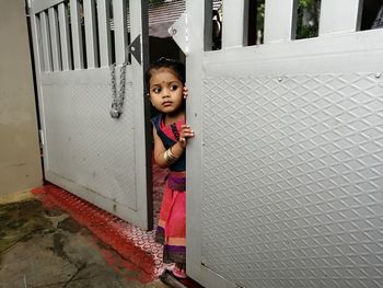 Low angle view of young woman standing against wall
