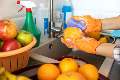 Midsection of man preparing fruits in container