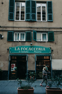 Information sign on street against building in city