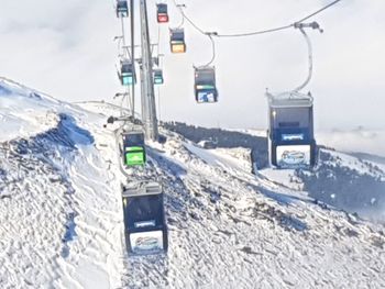 Telephone booth on snow covered mountain against sky