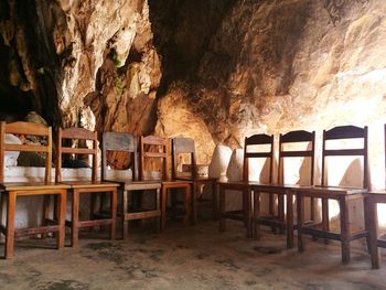 Empty chairs and table against rock formation