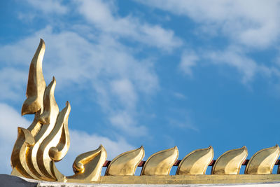 Low angle view of statues on building against sky