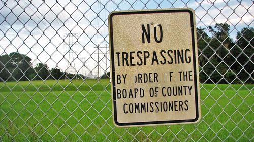 Warning sign on chainlink fence