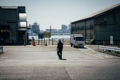 Man walking on road against buildings in city