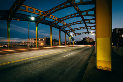 Illuminated street light on road in city