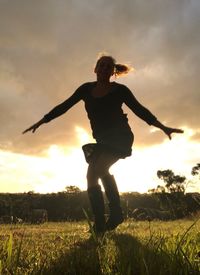Low angle view of boy jumping on field against sky