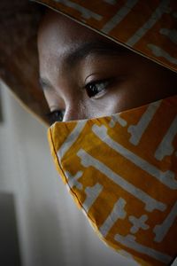 Close-up portrait of a young woman covering face