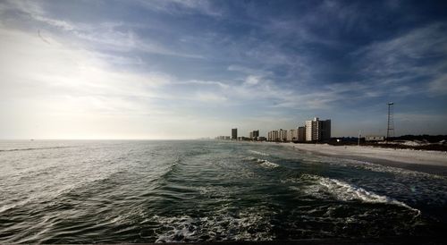 Scenic view of sea by buildings against sky