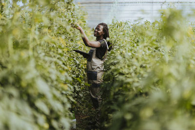 Smiling female farmer working at greenhouse