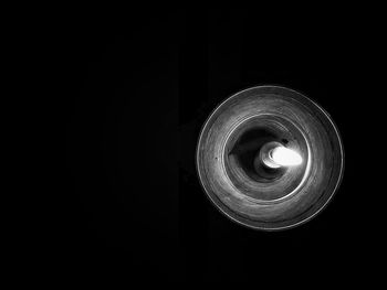 Low angle view of illuminated light bulb against black background