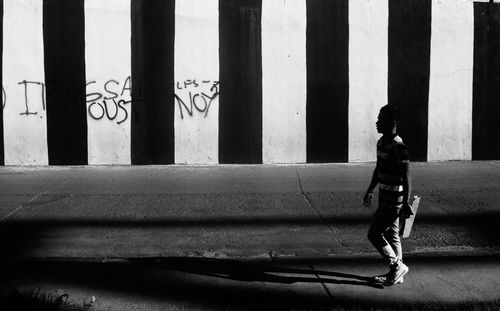 Side view of boy walking on road