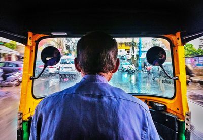 Rear view of man traveling in bus