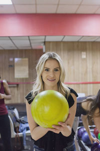 A young woman with a yellow bowling ball.