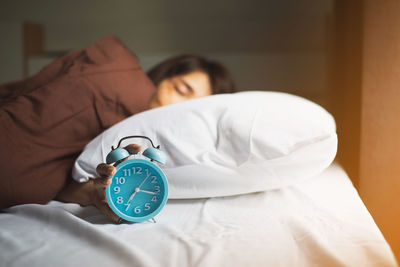 Midsection of woman sleeping on bed at home